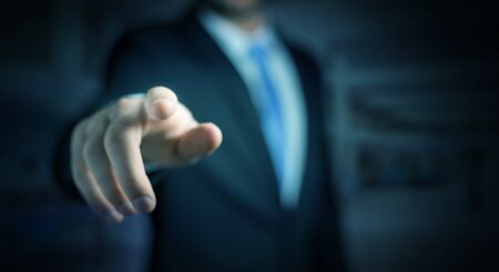 Businessman on blurred background pointing his fingerの写真素材