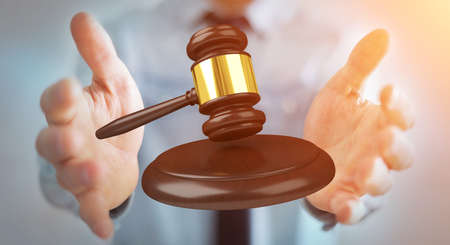 Businessman on blurred background with justice hammer 3D renderingの写真素材