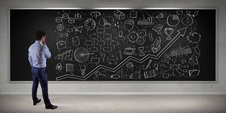 Businessman in modern interior watching a project sketch on a board 3D renderingの写真素材