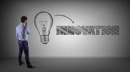 Businessman in modern interior watching innovation sketch on a wall 3D renderingの写真素材