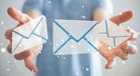 Businessman on blurred background holding 3D rendering flying email icon in his handの写真素材