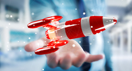 Businessman on blurred background holding red rocket in his hand 3D rendering