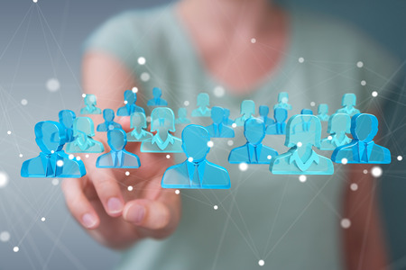 Businesswoman on blurred background holding and touching 3D rendering group of blue peopleの写真素材