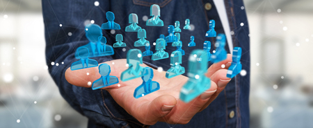 Businessman on blurred background holding 3D rendering group of blue peopleの写真素材
