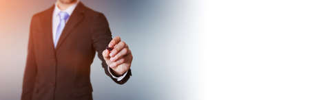 Panorama view of a businessman writing with a pen on a digital screenの写真素材