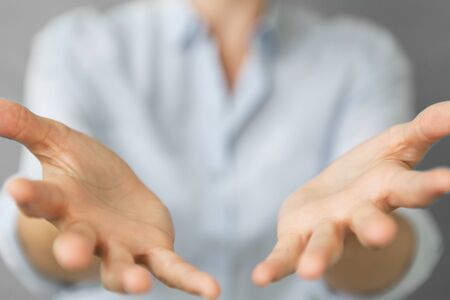 Businesswoman opening both hand on blurred backgroundの写真素材