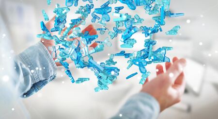 Businessman on blurred background holding 3D rendering group of blue peopleの写真素材