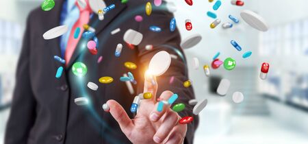 Businessman on blurred background holding and touching floating medicine pills 3D renderingの写真素材