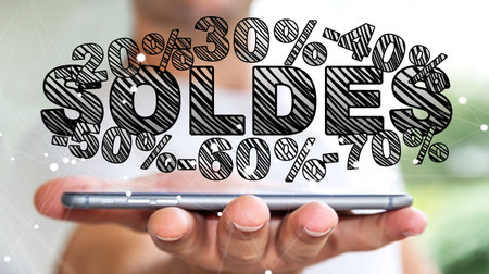 Businessman on blurred background holding sales icons over his phone 3D renderingの写真素材