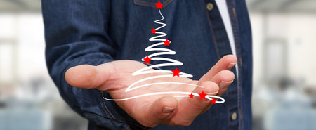 Businessman on blurred background holding and touching christmas trees sketchの写真素材