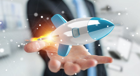 Businessman on blurred background holding and touching a rocket 3D rendering