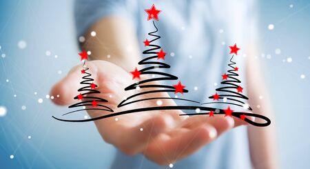 Businessman on blurred background holding and touching christmas trees sketchの写真素材