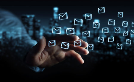 Businessman on blurred background holding and touching floating emails sketch