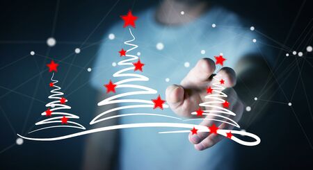 Businessman on blurred background holding and touching christmas trees sketchの写真素材