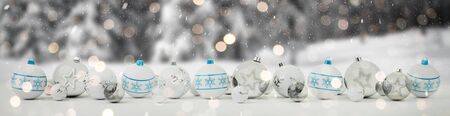 White and blue christmas baubles lined up on snow background 3D renderingの写真素材