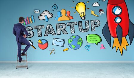 Businessman in modern interior watching startup sketch on a wall 3D renderingの写真素材