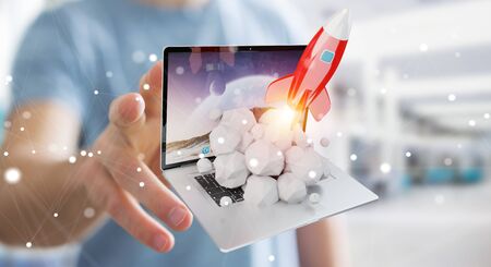 Businessman on blurred background with rocket launching from a laptop 3D renderingの写真素材