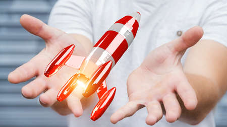 Businessman on blurred background holding red rocket in his hand 3D renderingの写真素材