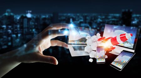 Businesswoman on blurred background connecting tech devices and startup rocket 3D renderingの写真素材