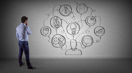 Businessman in modern interior watching a project sketch on a wall 3D renderingの写真素材