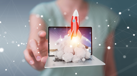 Businesswoman on blurred background with rocket launching from a laptop 3D renderingの写真素材