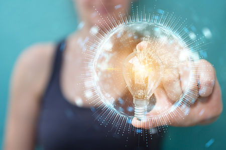 Businesswoman on blurred background holding a lighbulb with connections in her hand 3D renderingの写真素材