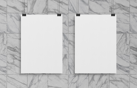 Two blank white poster hanging up with in front of marble wall clips mockupの写真素材