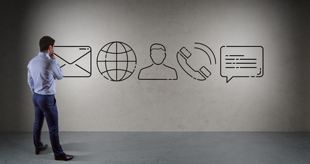 Businessman watching thin line contact icon on a wallの写真素材