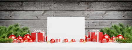 Blank Christmas card laying on red baubles and gift on wooden background 3D renderingの写真素材