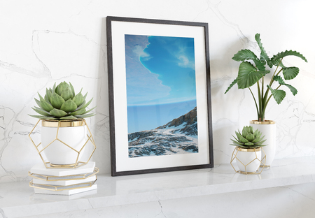 Black frame leaning on white shelve in bright marble interior with plants and decorations mockup 3D renderingの写真素材