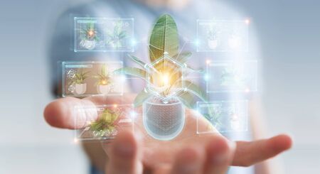 Man on blurred background holding and touching holographic projection of a plant with digital analysis 3D renderingの写真素材