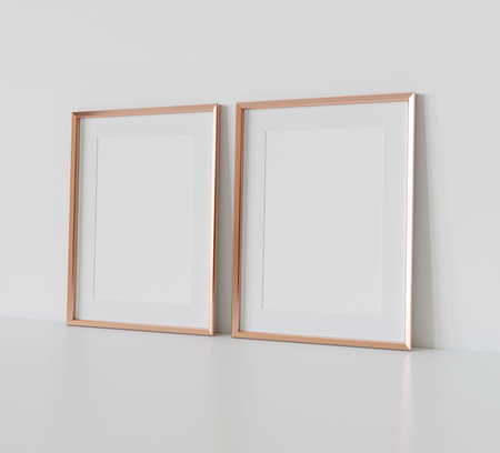 Two golden rectangular frames leaning on white floor in interior mockup. Template of pictures framed...