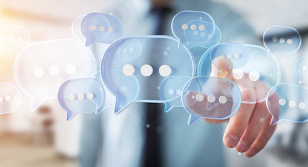Man touching with his fingers digital blue speech bubbles talk icons. Minimal conversation or social media messages floating in front of businessman hand. 3D renderingの写真素材