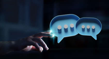 Man in dark touching with his fingers digital colorful speech bubbles talk icons. Minimal conversation or social media messages floating in front of businessman hand. 3D renderingの写真素材