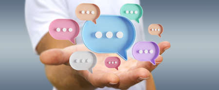 Man touching with his fingers digital colorful speech bubbles talk icons. Minimal conversation or social media messages floating in front of businessman hand. 3D renderingの写真素材