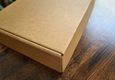 Brown carboard box mockup. Template of a carton packaging on wooden surface