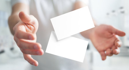 Business cards floating between man's handsの写真素材