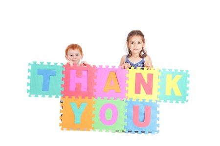 Two kids holding up sign saying thank you. Isolated on white.の写真素材