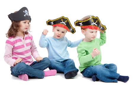 Three children playing in kids party pirate hats. Isolated on white.の写真素材