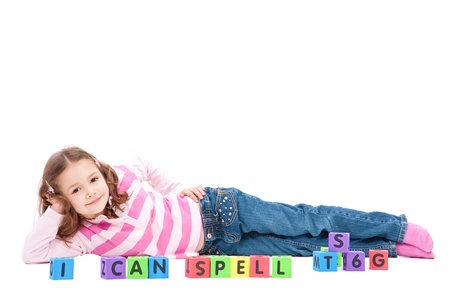 Girl with kids blocks saying I can spell. Isolated on white.の写真素材