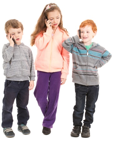 Group of three children talking on kids mobile phones. Isolated on white.の写真素材