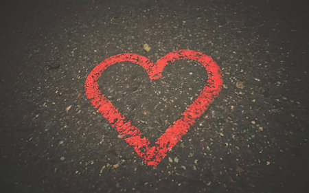 Red heart painted on the asphalt background. Love concept. Toned.の素材