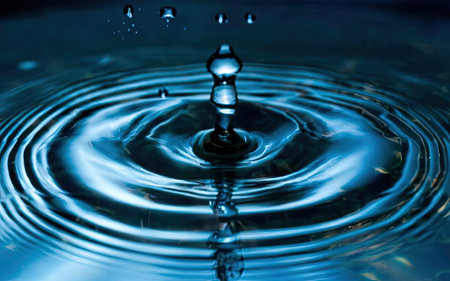 Water drop with ripples and ripples on a dark blue backgroundの素材