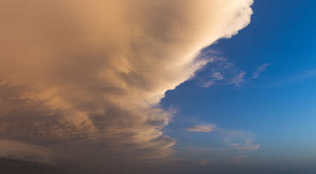 Contrasting red clouds against a blue skyの写真素材