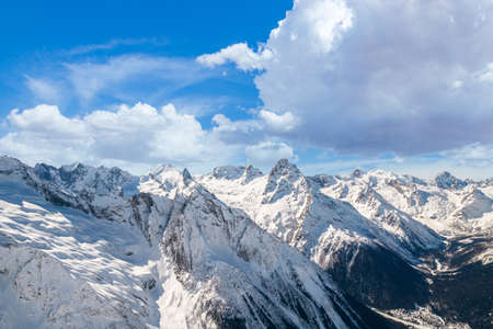 Fluffy cloud over mountains in winterの写真素材