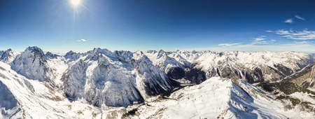 Beautiful panorama of mountain peaks on a sunny day photo from a droneの写真素材