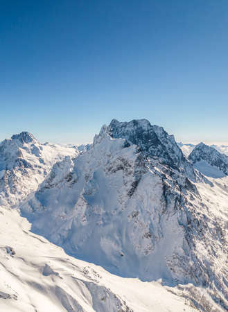 Mountain peak covered with snow under a clear skyの写真素材