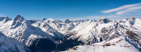 Panorama of winter snowy mountains in Caucasus region in Russia with ski lift and ski trackの写真素材