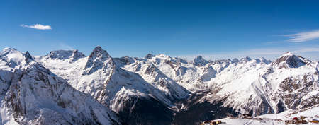 Panoramic view of winter snowy mountains in Caucasus region in Russia with blue skyの写真素材