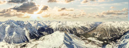 sunrise over snowy mountains and valleyの写真素材